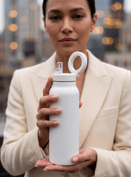Professional woman holding SIPPLE bottle with city backdrop